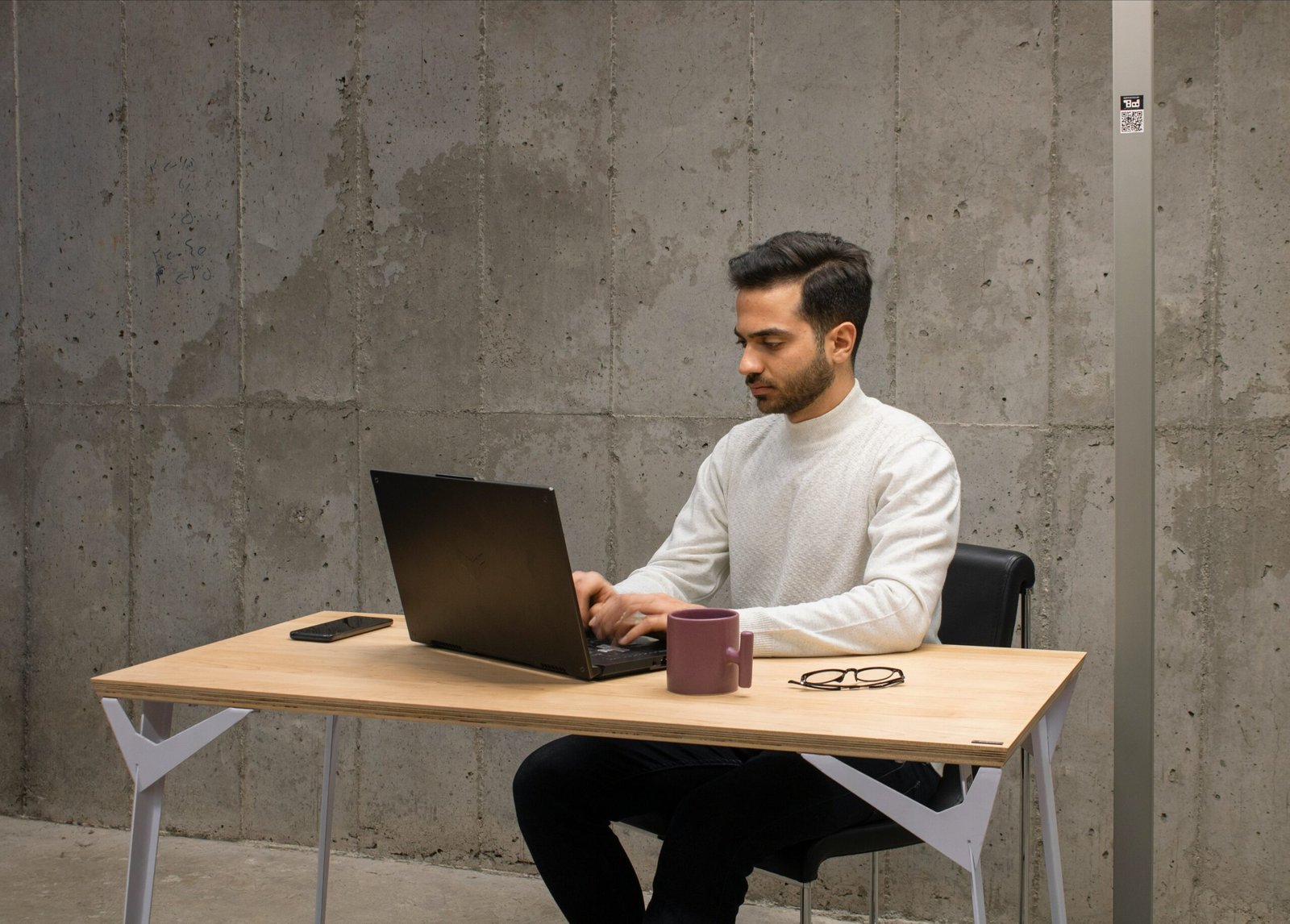 a man sitting at a table using a laptop computer